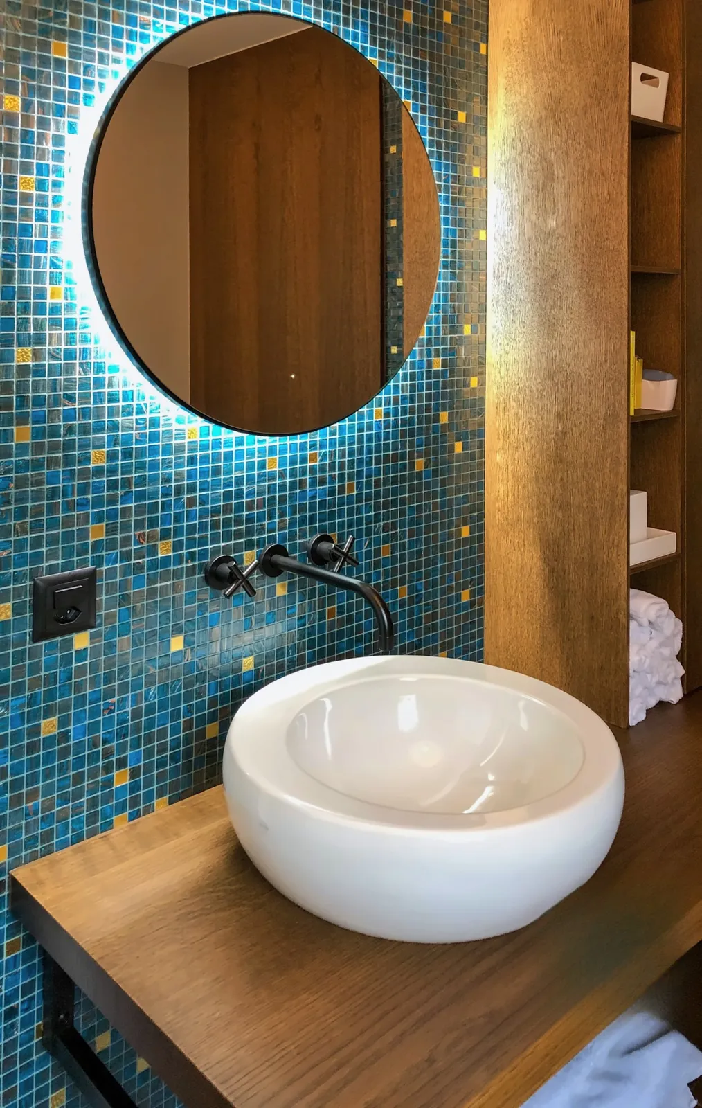 Gäste-WC im Erdgeschoss: Aufsatzbecken auf Holz, runder Spiegel mit Hinterleuchtung
