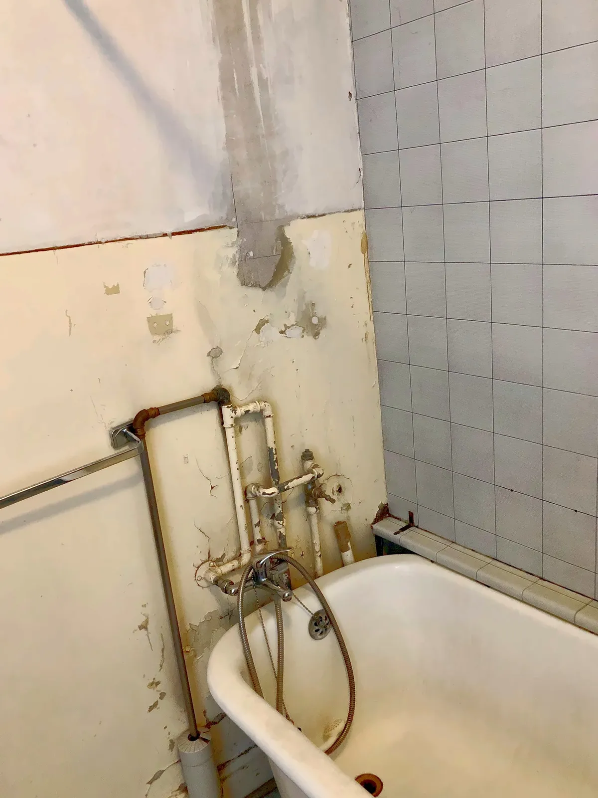 Vorher: alte Wanne, Leitungen offen auf der Wand