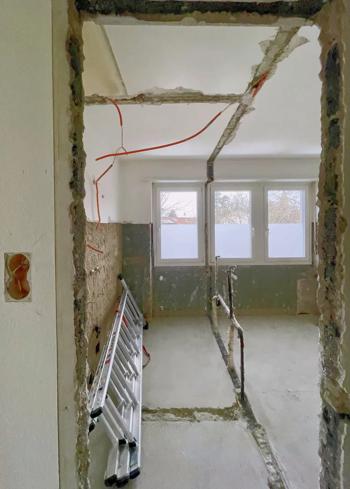 Im Rückbau: der Raum bis auf den Rohbau geöffnet, Leitungen in Boden und Decke